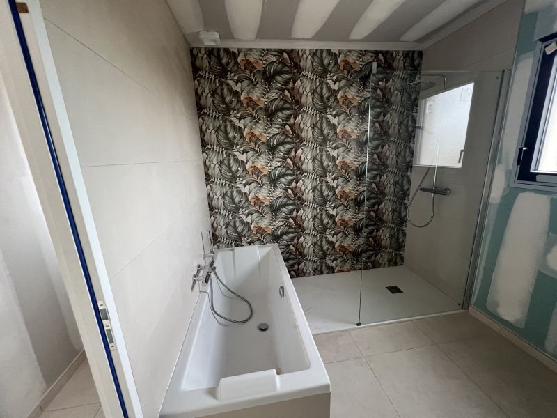 Salle de bains du rez-de-chaussée, baignoire perpendiculaire au bac à douche extra-plat