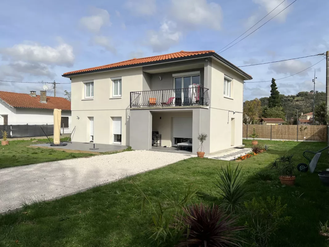 Façade jardin de la villa rénovée à Pins-Justaret après transformation lourde, balcon métal conservé et terrasse en rez-de-chaussée
